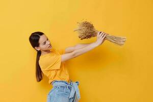 photo pretty girl fashion in yellow t-shirt dried flowers bouquet posing isolated background