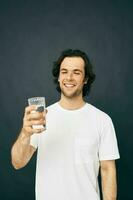 man glass of water in his hands emotions posing beige background photo