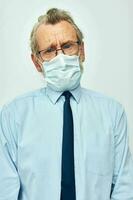 Portrait elderly man in shirt with tie medical mask safety light background photo