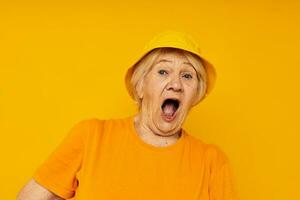 elderly woman in yellow t-shirts hat posing isolated background photo