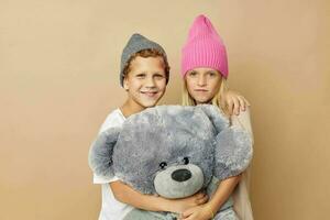 pequeño chico y niña en sombreros con un osito de peluche oso amistad estilo de vida inalterado foto