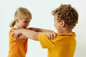 Cute preschool kids in yellow t-shirts standing side by side childhood emotions unaltered photo