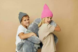 Portrait of cute children in hats with a teddy bear friendship isolated background photo