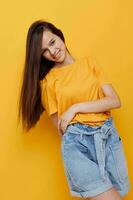 optimista joven mujer Moda en amarillo camiseta mezclilla pantalones cortos estilo de vida inalterado foto