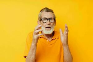 Portrait of happy senior man wearing glasses yellow shirt posing unaltered photo