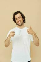 Cheerful man in a white T-shirt with a mug in hand Lifestyle unaltered photo