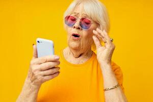 elderly woman in fashionable glasses with a smartphone close-up emotions photo