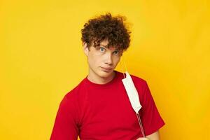 guy with red curly hair wearing a red t-shirt medical mask on the face posing yellow background unaltered photo
