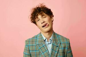 guy with red curly hair in a suit business look posing emotions pink background unaltered photo