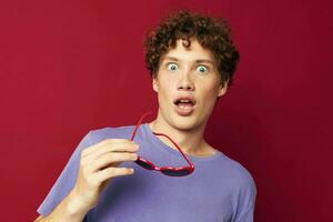 portrait of a young curly man hand gestures heart shaped glasses posing isolated background photo