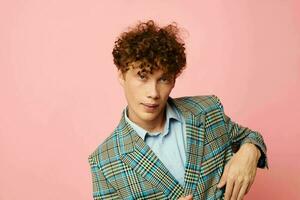 Young curly-haired man checkered blazer elegant style posing fashion isolated background unaltered photo