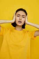 photo pretty girl yellow t-shirt summer style hand gesture yellow background