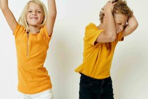 cute boy and girl in yellow t-shirts childhood entertainment studio photo