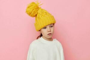 Portrait of happy smiling child girl fun in a yellow hat fun pink background photo