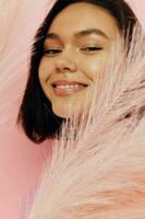 beautiful girl in a pink vest with feathers in his hands Lifestyle unaltered photo