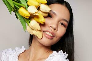 bonito morena con un ramo de flores de flores sonrisa de cerca aislado antecedentes inalterado foto