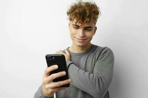 hermoso chico mirando a el teléfono Moda estilo de vida inalterado foto