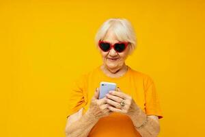 elderly woman in dark glasses talking on the phone close-up emotions photo