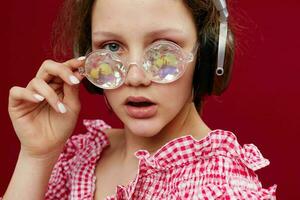 girl wearing headphones glasses with diamond close-up red background unaltered photo