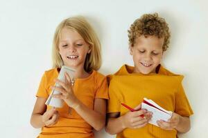 Small children lie on the floor with notepads and pencils isolated background unaltered photo