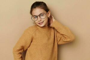 retrato de contento sonriente niño niña con lentes emociones gesto manos beige antecedentes foto