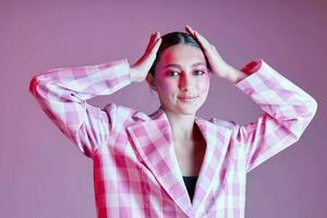 Portrait of beautiful young woman luxury clothing fashion plaid blazer pink background unaltered photo