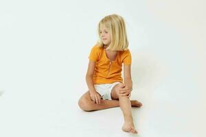 cute girl with blond hair sitting on the floor photo