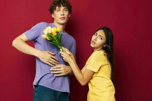 young boy and girl gift bouquet of flowers fun red background unaltered photo