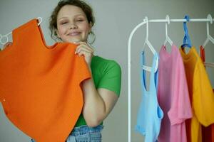 funny girl ironing clothes on a hanger wardrobe light background unaltered photo