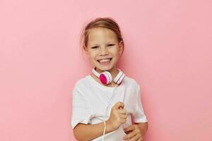Portrait of happy smiling child girl in a white t-shirt with headphones childhood unaltered photo