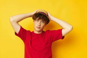guy with red curly hair emotions red t-shirt hat studio yellow background unaltered photo