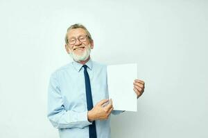 old man holding documents with a sheet of paper light background photo