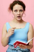 beautiful woman learning with notebook and pen pink color background unaltered photo