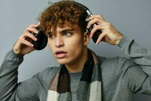 hermoso chico elegante estilo a cuadros bufanda auriculares aislado antecedentes foto