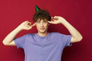 Cheerful guy with a cap on his head holiday red background photo