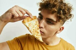 kinky guy in a yellow t-shirt eating pizza Lifestyle unaltered photo