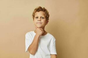 Photo of young boy in a white t-shirt posing fun isolated background