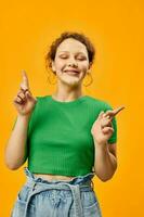 cheerful girl in green t-shirt earrings posing fashionable style photo