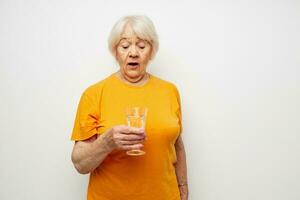 Cheerful elderly woman holding a glass of water health close-up emotions photo