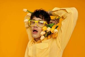 Photo of romantic young boyfriend with a fashionable hairstyle in yellow shirts with flowers yellow background unaltered