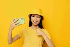 Portrait Asian beautiful young woman in a yellow hat and T-shirt talking on the phone Lifestyle unaltered photo