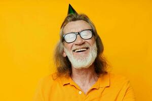 Portrait of happy senior man fun birthday cap on the head isolated background photo