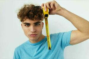 Attractive man yardstick in hand in blue t-shirts Lifestyle unaltered photo