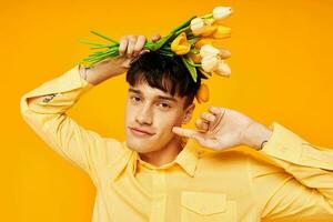 bonito hombre con un ramo de flores de flores posando un regalo estilo de vida inalterado foto