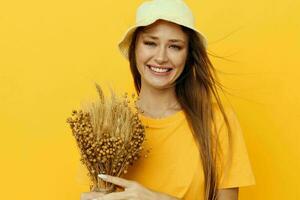 photo pretty girl in yellow T-shirts, dried flowers in hands isolated background
