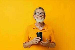 Portrait of happy senior man in a yellow T-shirt a glass with a drink cropped view photo