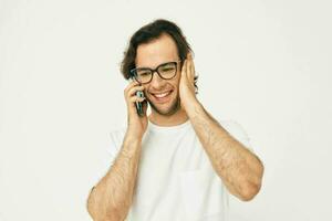 hermoso hombre en un blanco camiseta comunicación por teléfono aislado antecedentes foto