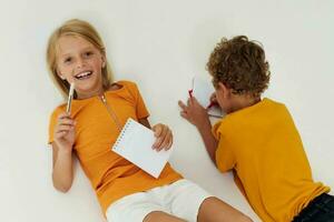 cheerful children drawing in notebooks lying on the floor childhood lifestyle unaltered photo