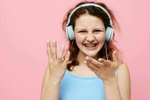 cheerful woman with headphones music posing pink background photo