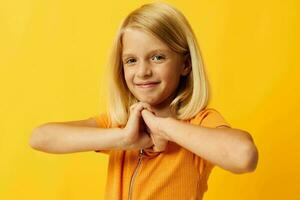 niño niña en un amarillo camiseta sonrisa posando estudio aislado antecedentes inalterado foto